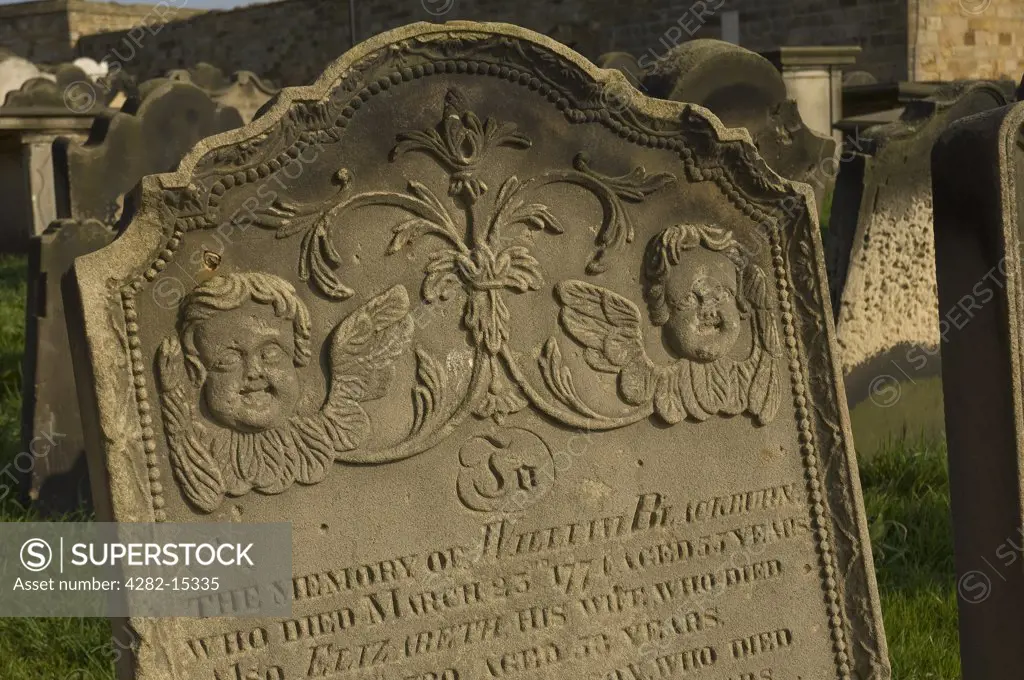 England, North Yorkshire, Whitby. A weathered headstone in St Mary's churchyard.