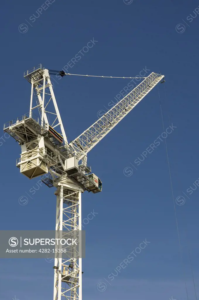 England, West Yorkshire, Leeds. A large construction crane against a blue sky.