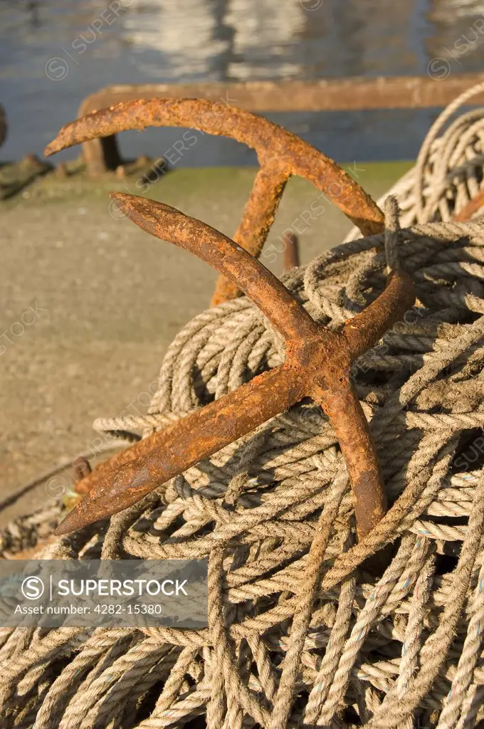 England, East Riding of Yorkshire, Bridlington. Rusty anchors and coiled rope on Bridlington Harbour.