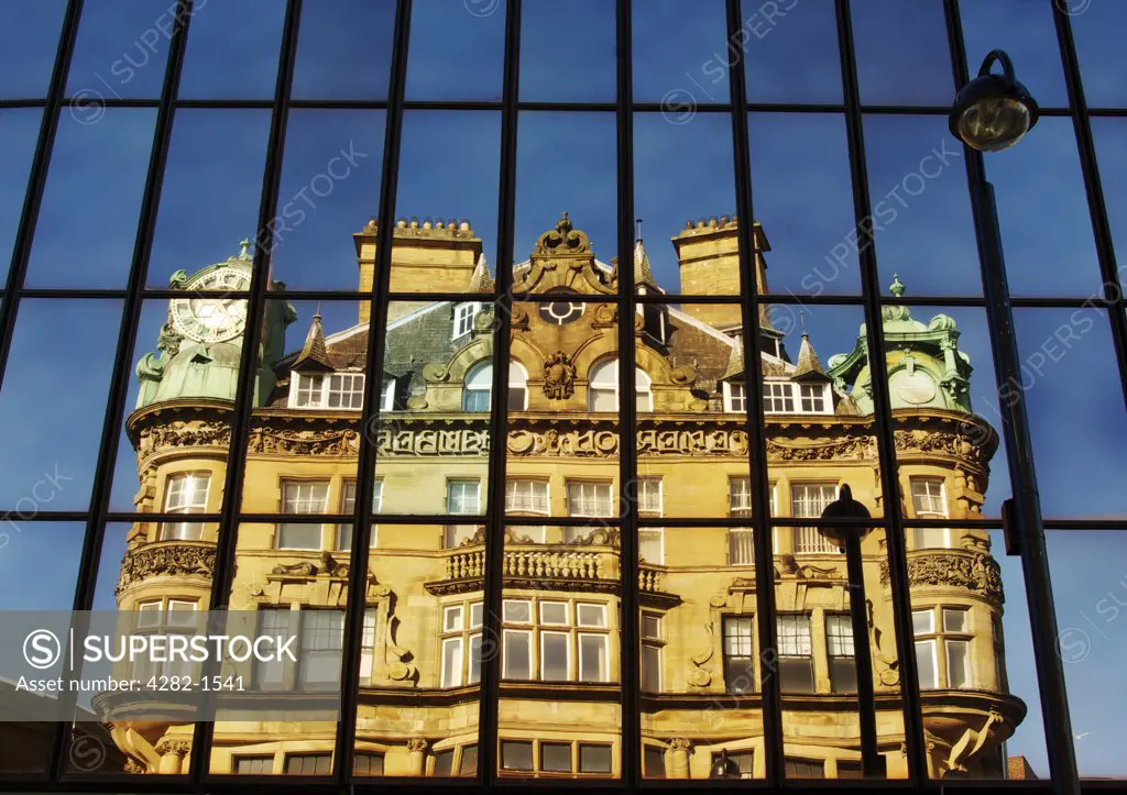 England, Tyne and Wear, Newcastle Upon Tyne. Historic building on Blackett Street reflected in glass panels.
