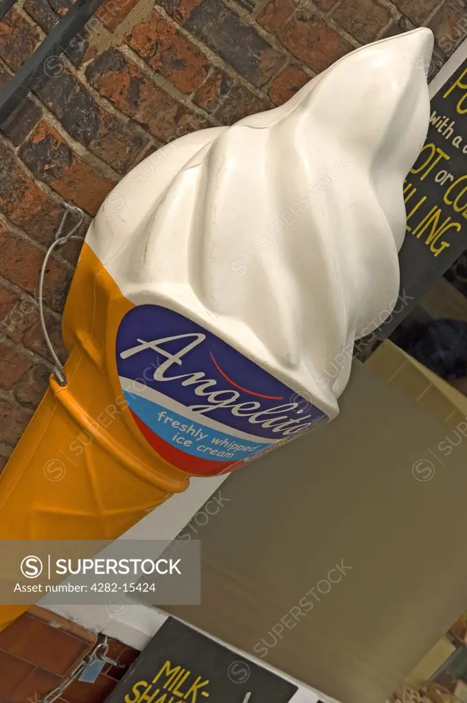 England, North Yorkshire, York. A giant ice cream cone fastened to a wall outside a shop advertising freshly whipped ice cream.