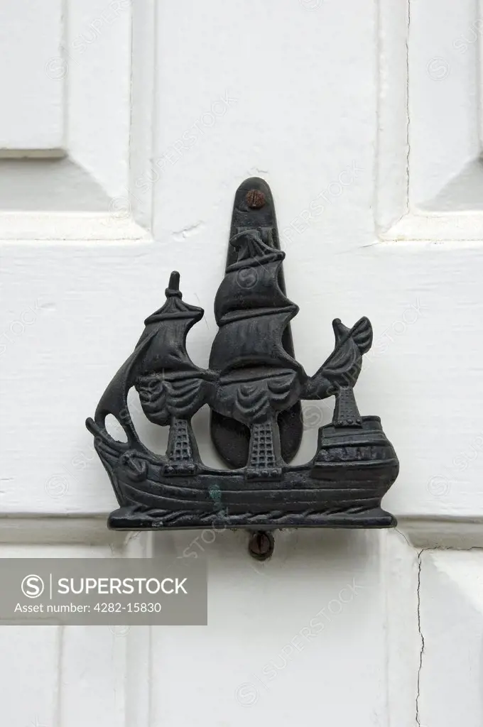 England, North Yorkshire, Robin Hoods Bay. A door knocker in the form of a ship.