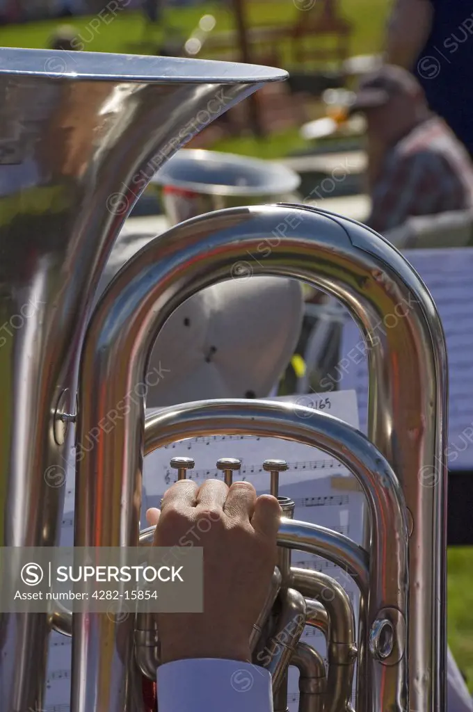 England, North Yorkshire, Gargrave. Close up of a man playing a tuba in a brass band performing at Gargrave Show, an annual country show near Skipton.