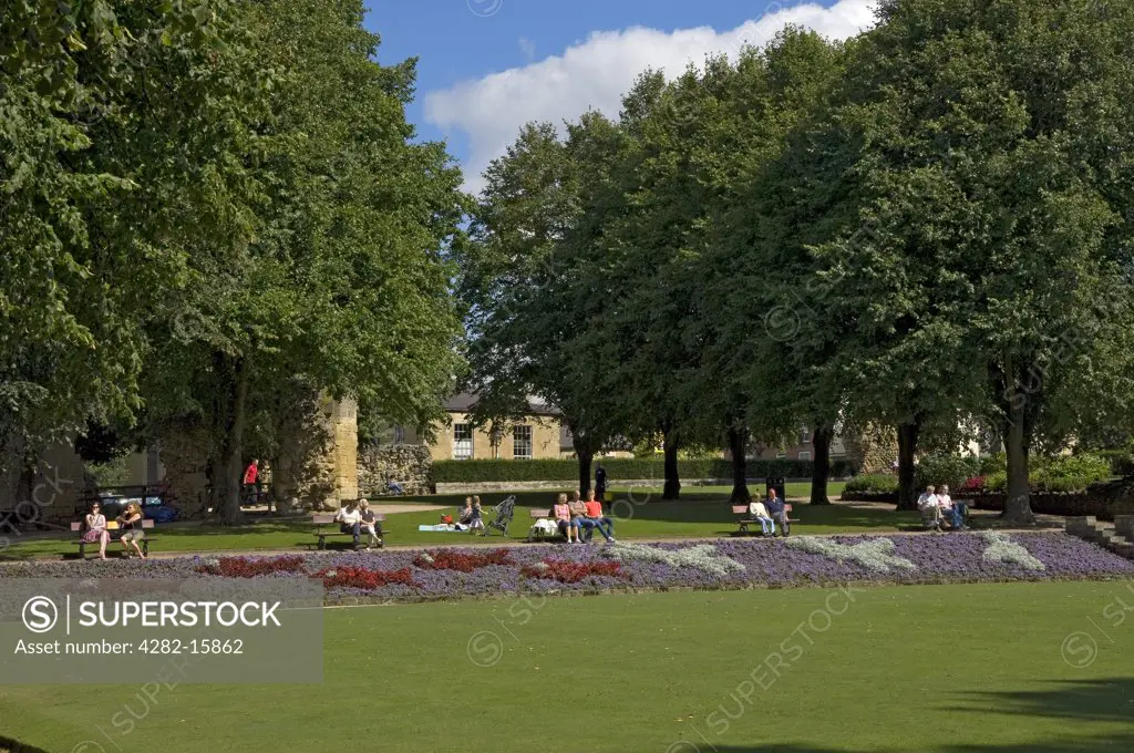 England, North Yorkshire, Knaresborough. People enjoying the summer sunshine in the grounds of Knaresborough Castle.