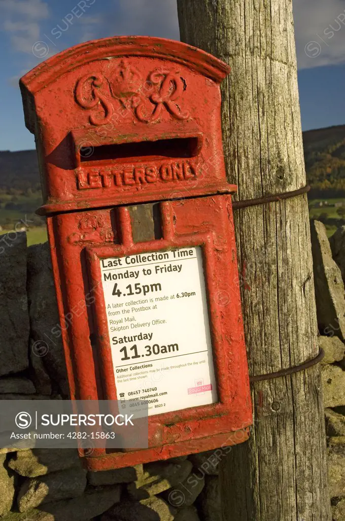 England, North Yorkshire, Upper Wharfedale . Old letterbox on a wooden post.
