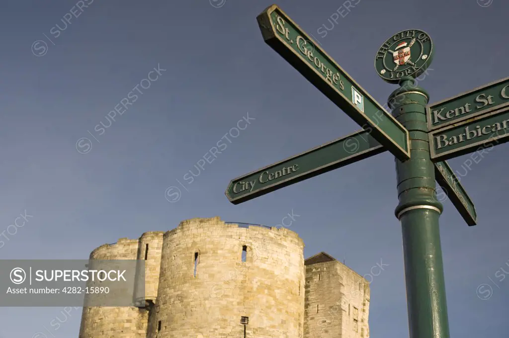 England, North Yorkshire, York. A tourist information signpost with Cliffords Tower in the background.