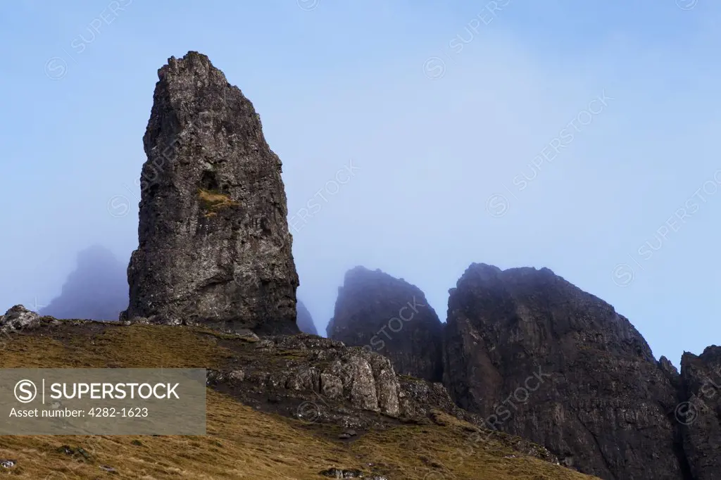Scotland, Isle of Skye, Trotternish. Mist hanging over the Old Man of Storr, dramatic pinnacles of rock remaining from ancient landslips on the Trotternish peninsula.