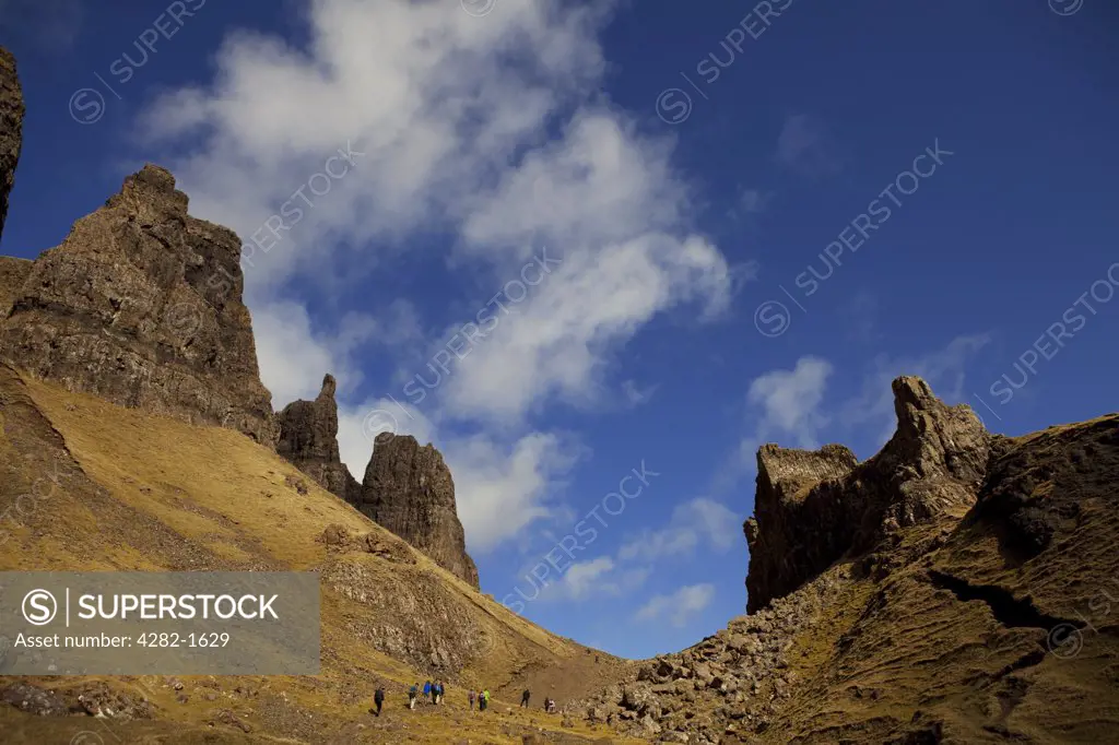 Scotland, Isle of Skye, Trotternish. A group of walkers work their way up the Quiraing beneath the Prison on the Trotternish peninsula.