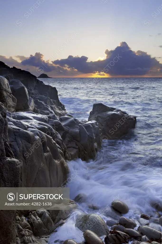 England, Cornwall, Porth Nanven. Sunset over the sea viewed from Porth Nanven, a beach sometimes referred to as 'Dinosaur Egg Beach' because of large deposit of ovoid boulders on the beach and foreshore.