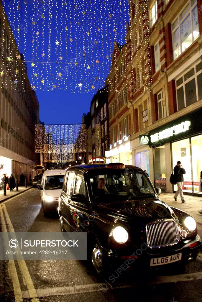 England, London, Oxford Street. London taxi with xmas lights above.