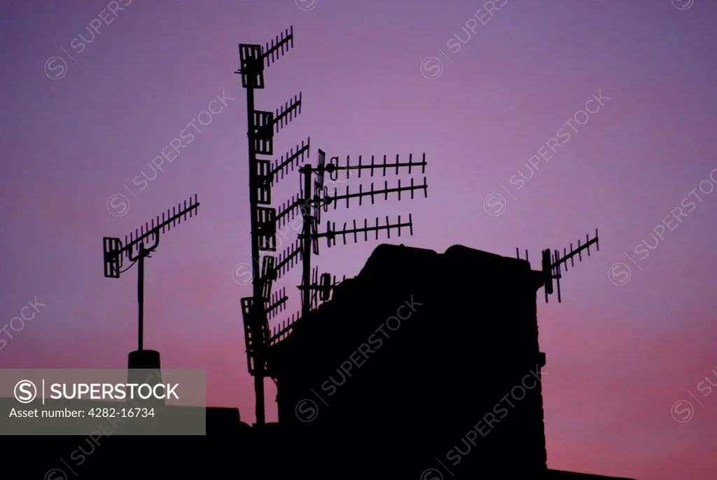 England, City of Brighton and Hove, Hove. TV aerials silhouetted against a purple sunset in Hove.