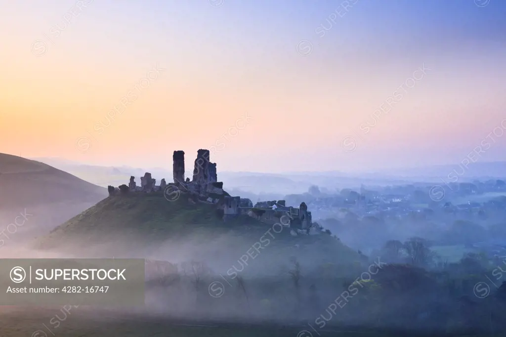 England, Dorset, Corfe Castle. Corfe Castle, dating back to the 11th century, shrouded in mist at sunrise.