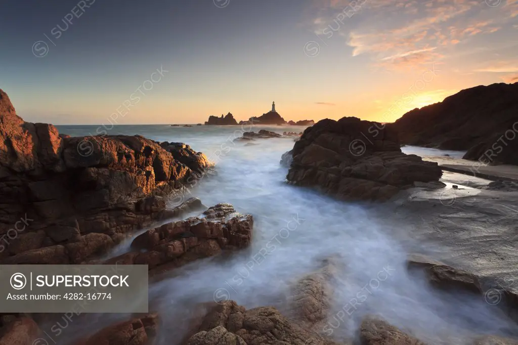 Channel Islands, Jersey, St Brelade. La Corbiere Lighthouse, the first in the British Isles to be built from concrete, at sunset.