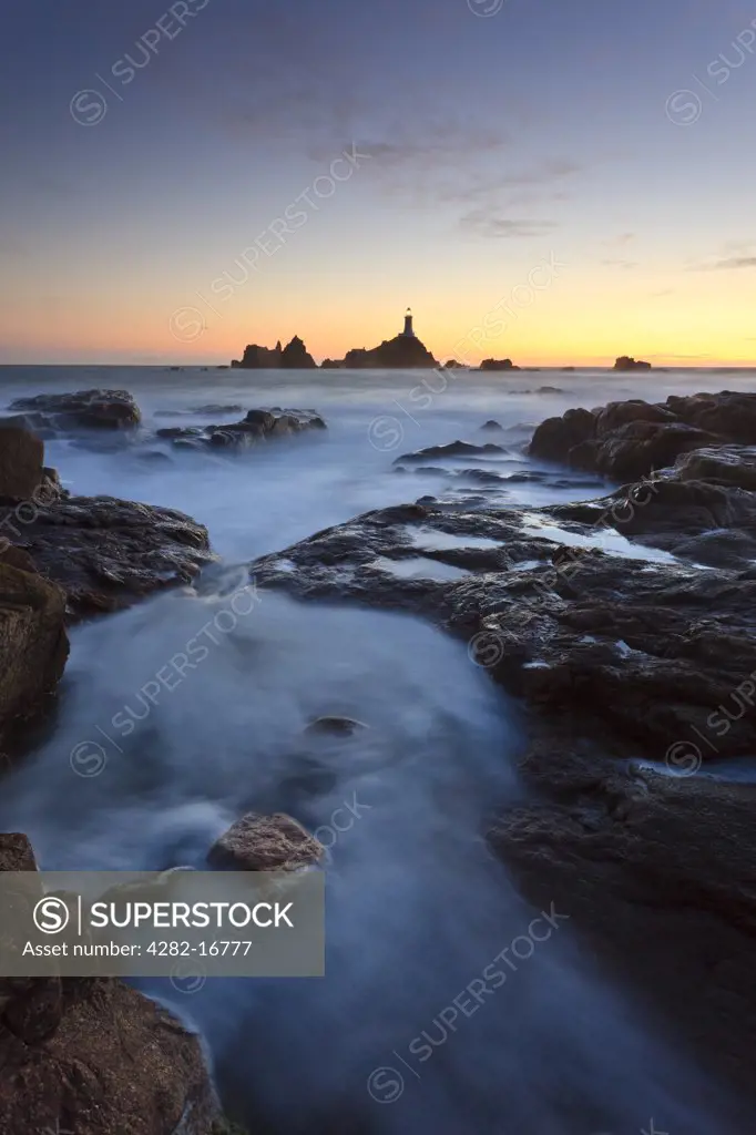 Channel Islands, Jersey, St Brelade. La Corbiere Lighthouse, the first in the British Isles to be built from concrete, at sunset.