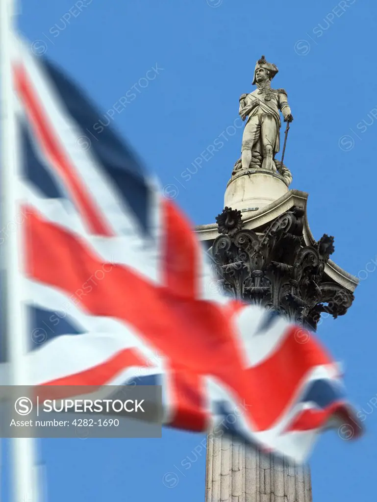 England, London, Trafalgar Square. Union Jack with Nelson's Column in background. The column was built between 1840 and 1843 to commemorate Admiral Horatio Nelson's death at the Battle of Trafalgar in 1805.