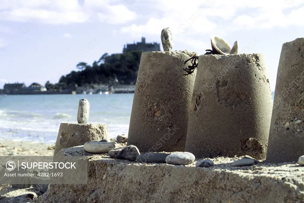 England, Cornwall, St. Michael's Mount. Sandcastle with St. Michael's Mount. St. Michael's Mount is a lofty pyramidal tidal island that is linked to Marazion by a natural causeway at low tide.