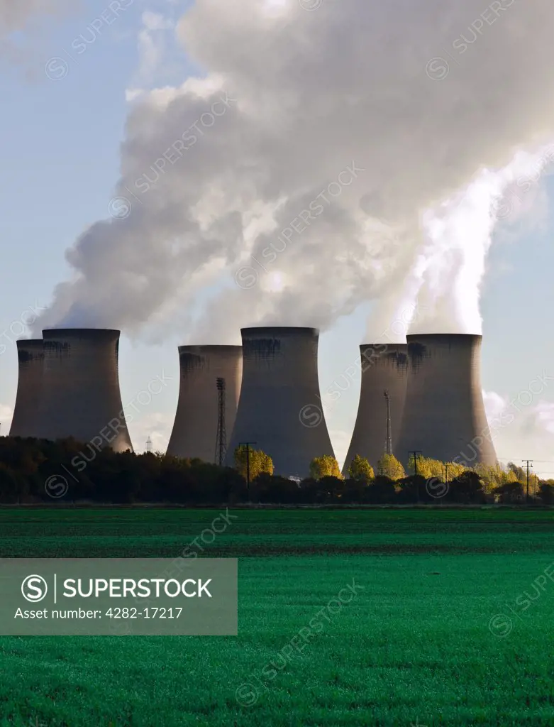 England, North Yorkshire, Drax. View over fields towards smoke billowing out of the cooling towers of Drax Power Station.