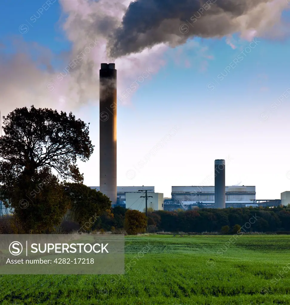 England, North Yorkshire, Drax. View over fields towards smoke pouring out of a chimney at Drax Power Station.