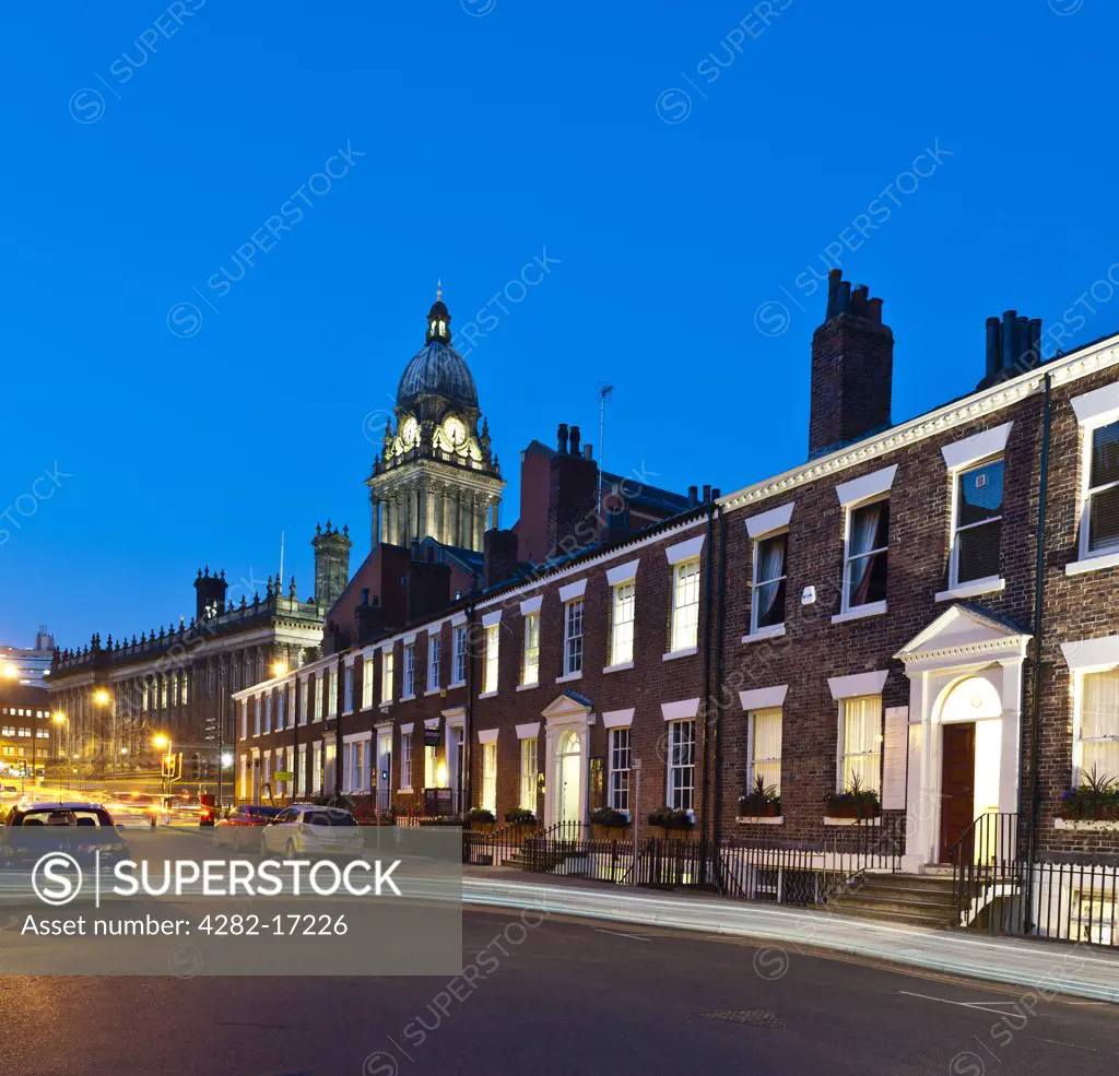 England, West Yorkshire, Leeds. Leeds Town Hall and Georgian terrace houses at night with light trail of passing car.