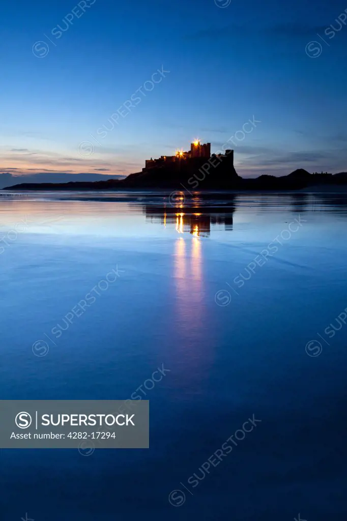England, Northumberland, Bamburgh. Bamburgh Castle, former home to the Kings of Northumbria, located on a large whinstone outcrop, silhouetted in the pre-dawn light.