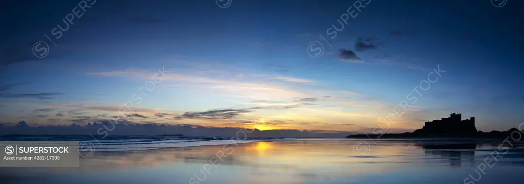 England, Northumberland, Bamburgh. View over the beach at dawn towards Bamburgh Castle, former home to the Kings of Northumbria.