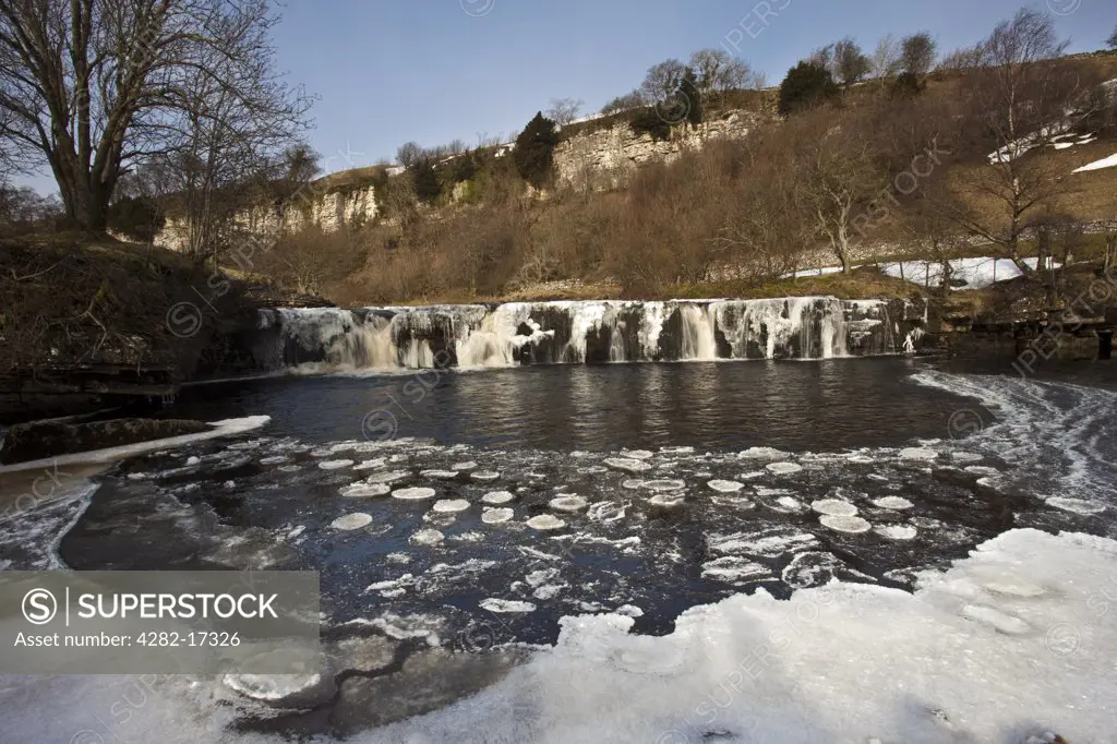 England, North Yorkshire, Upper Swaledale. Wain Wath Force on the River Swale, frozen in winter, in the Yorkshire Dales National Park.