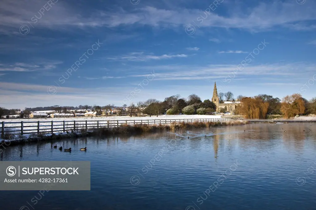 England, North Yorkshire, Brompton-by-Sawdon. All Saints' Church in a snow covered landscape in Brompton-by-Sawdon.