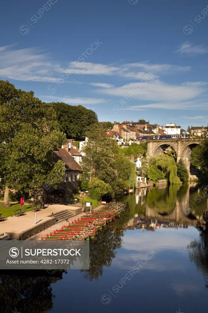 England, North Yorkshire, Knaresborough. Rowing boats for hire on the River Nidd. The Knaresborough Viaduct, built in 1851 to carry Victorian rail traffic over the Nidd Gorge, is in the background.
