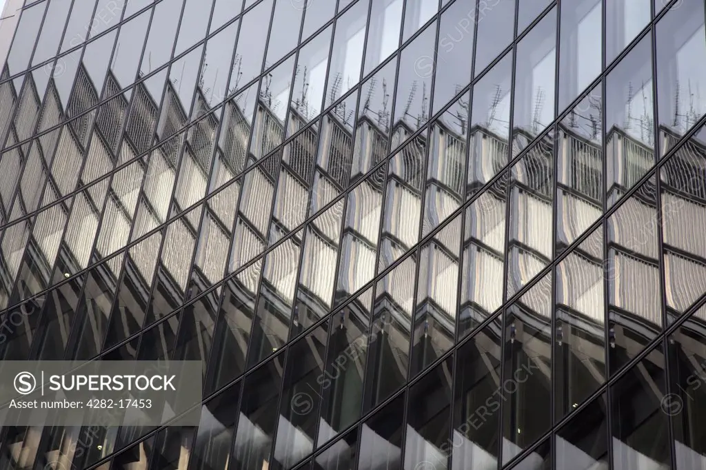 England, London, The City of London. Abstract patterns from reflections in a glass clad office building in the City of London.