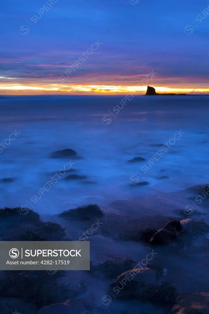 England, North Yorkshire, Saltwick Bay. Dawn over Black Nab in Saltwick Bay near Whitby on the North Yorkshire Coast.