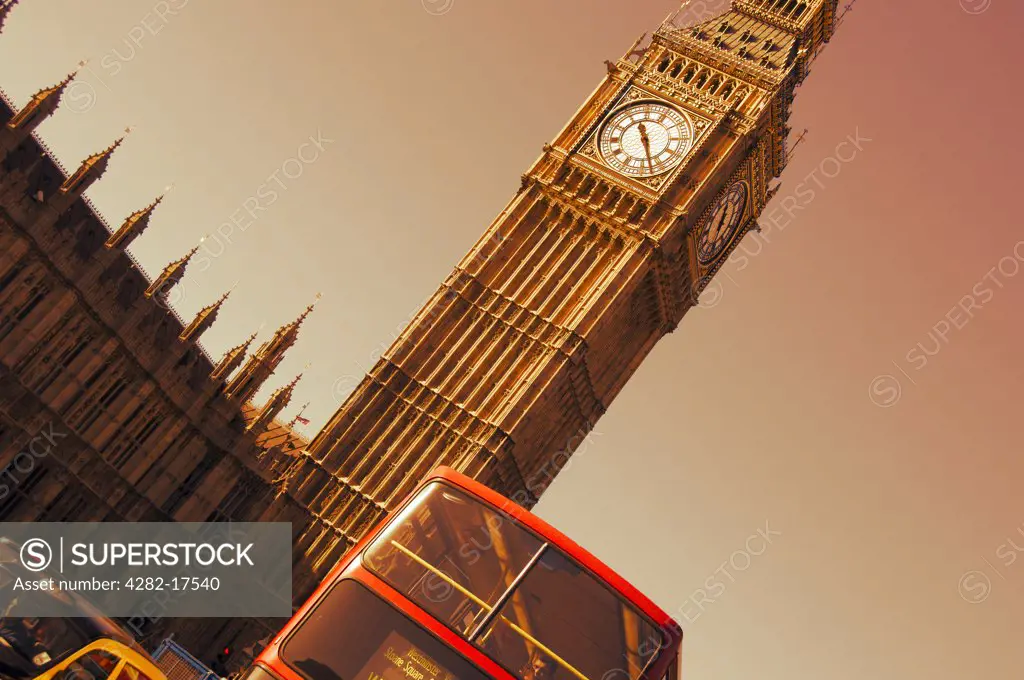 England, London, Westminster. Black taxi cab and red double decker bus passing Big Ben, one of London's most iconic landmarks.