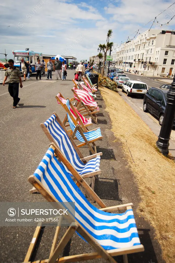 England, West Sussex, Worthing. Empty deckchairs blowing in the sea breeze on the promenade at Worthing.