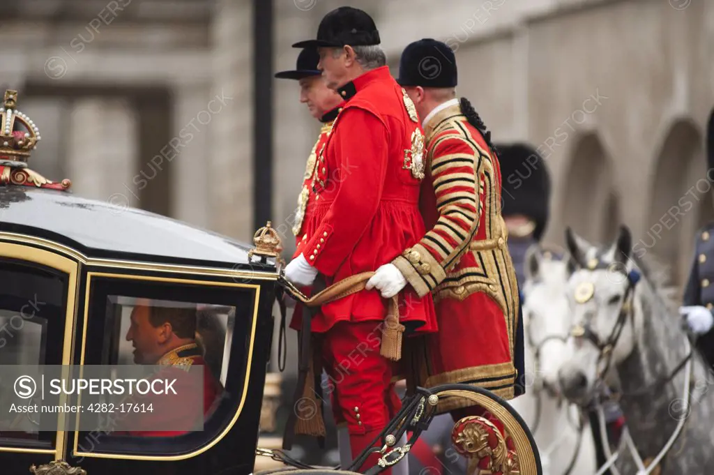 England, London, Westminster. A coach with liveried coachmen enters Whitehall from Horseguards Parade during the State Opening of Parliament in central London.