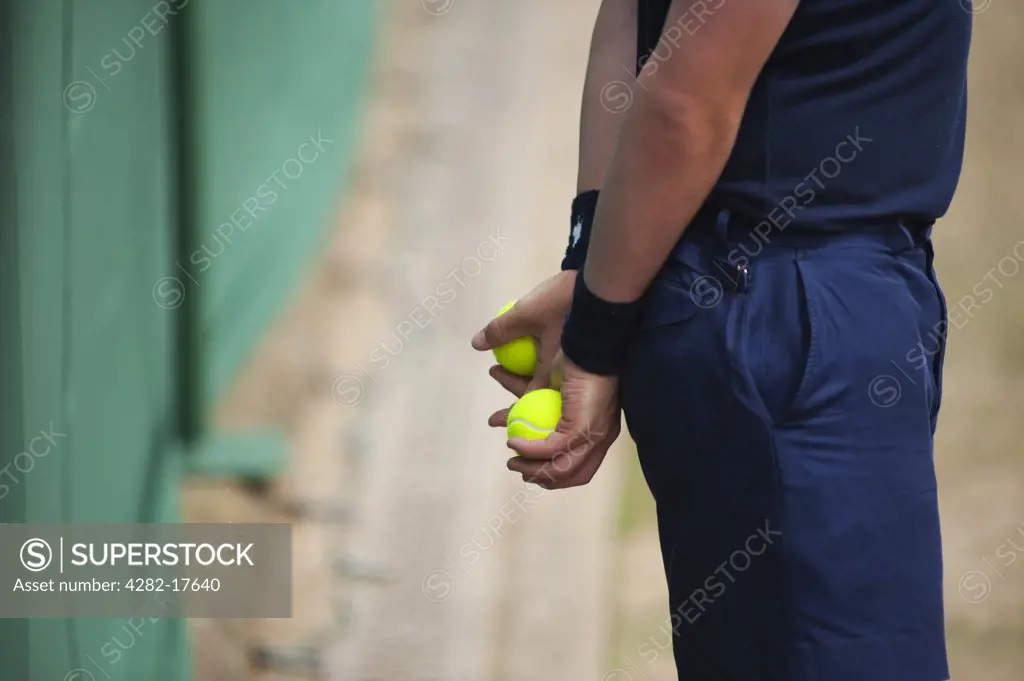 England, London, Wimbledon. Ball boy holding tennis balls during a match at the Wimbledon lawn tennis championships in London.