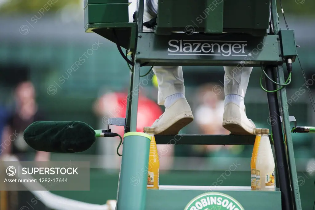 England, London, Wimbledon. The legs of a tennis umpire sitting on an umpires chair on court at the Wimbledon lawn tennis championships in London.