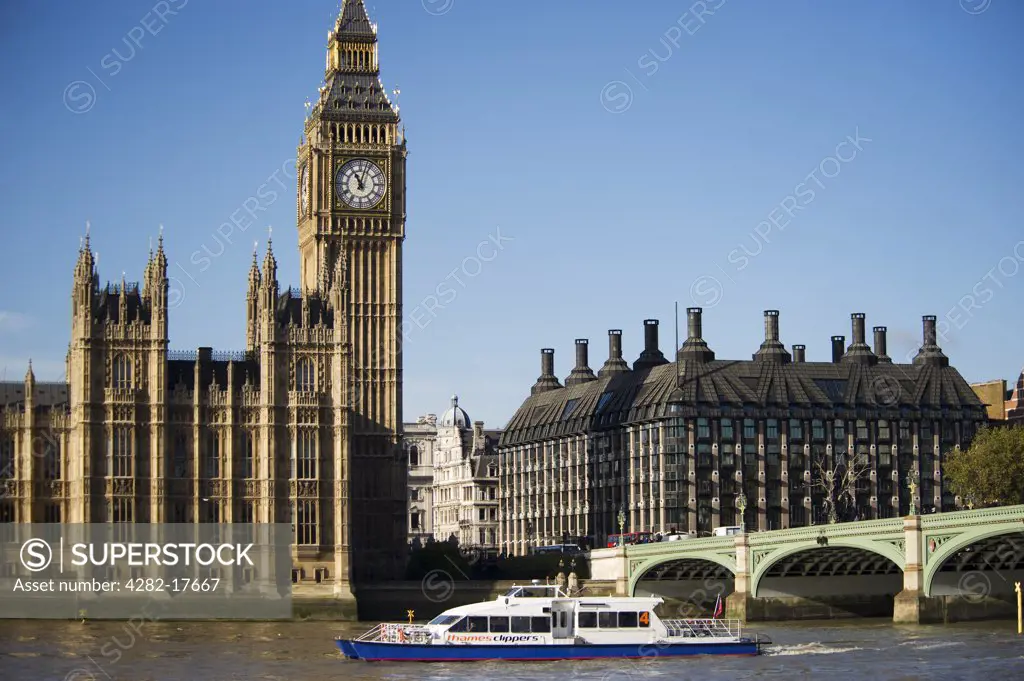 England, London, Westminster. A passenger boat passing under Westminster Bridge on the river Thames in front of the iconic clocktower of Big Ben and Houses of Parliament in central London.