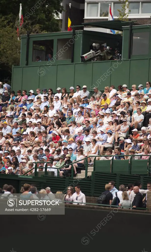 England, London, Wimbledon. Spectators watching a tennis match on court 18 at the Wimbledon lawn tennis championships in London.