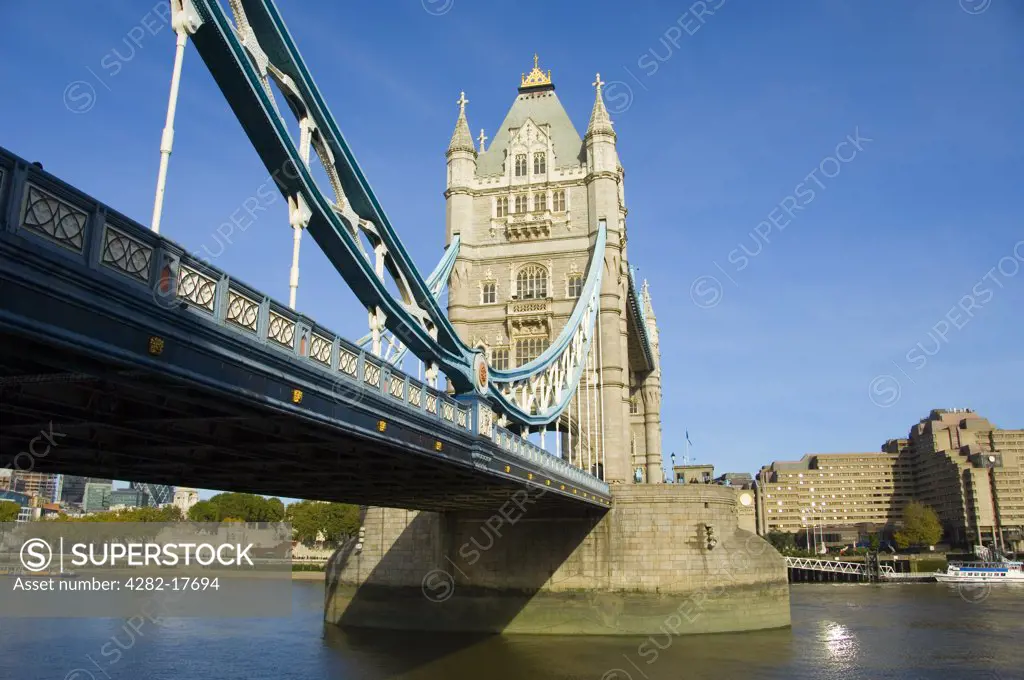 England, London, Tower Bridge. The iconic Tower Bridge over the River Thames in central London at low tide with Tower Hotel in the background.