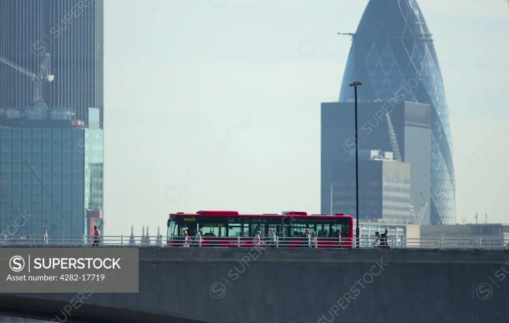 England, London, Waterloo. A red bus and pedestrians crossing Waterloo Bridge over the River Thames, with Tower 42 and 30 St Mary Axe office buildings in the City of London in the background.
