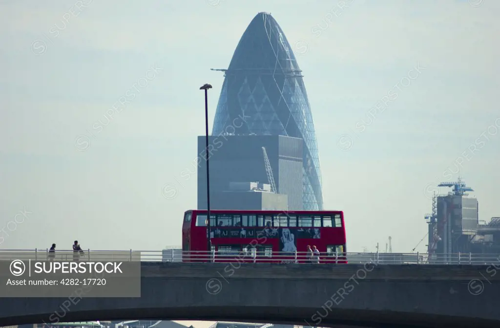 England, London, Waterloo. A red bus and pedestrians crossing Waterloo Bridge over the River Thames, with 30 St Mary Axe office building in the City of London in the background.