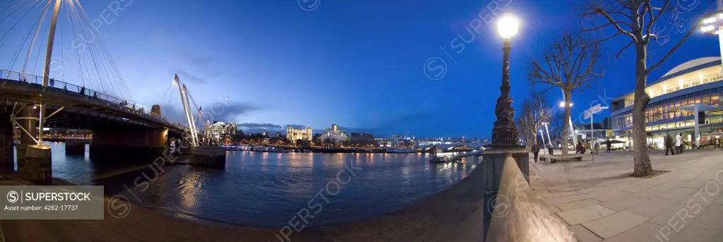 England, London, South Bank. Evening panoramic view of the river Thames in London from the South Bank featuring the Golden Jubilee footbridge and Royal Festival Hall.