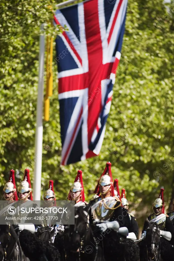 England, London, The Mall. A mounted troop of the Blues and Royals pass a Union flag hanging in The Mall as part of the Royal Wedding celebrations in central London.