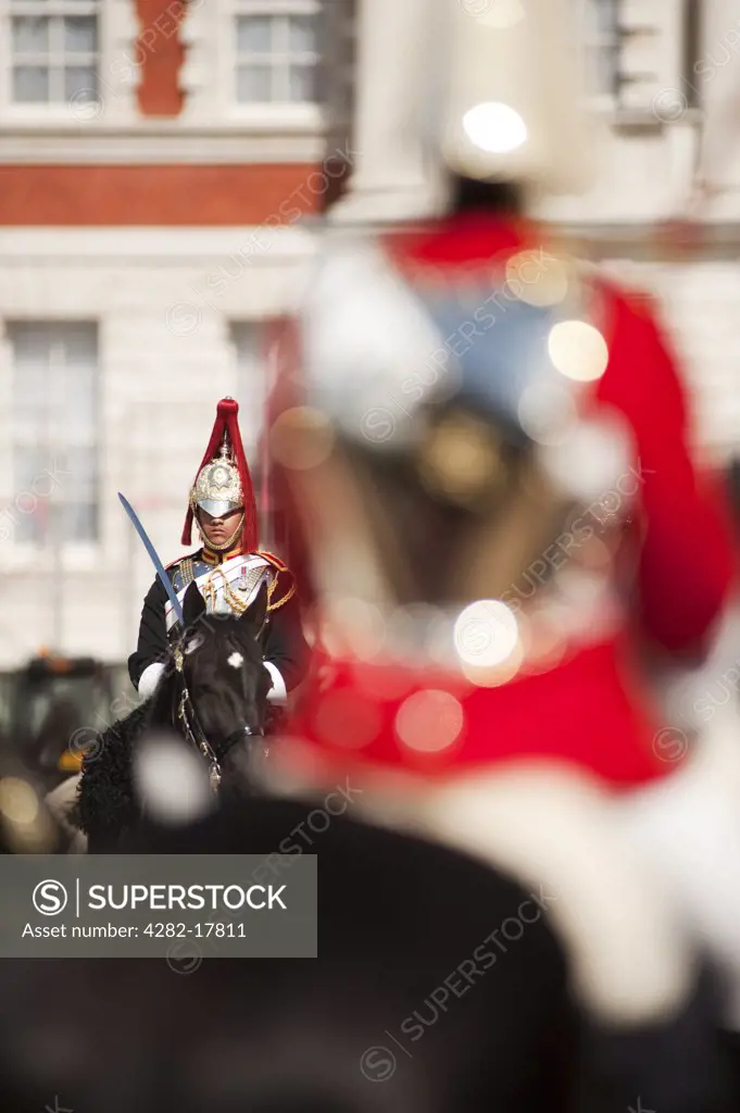 England, London, Horse Guards Parade. Soldiers from The Life Guards (red tunics) and Blues and Royals (blue tunics) regiments (together they form the Household Cavalry) participating in the Changing of the Guard ceremony in Horse Guards Parade.