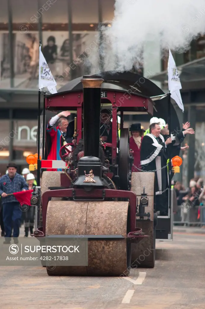 England, London, City of London. Members from the Worshipful Company of Paviors waving to spectators from their float pulled by a steam powered road roller at the Lord Mayor's Show in the City of London.
