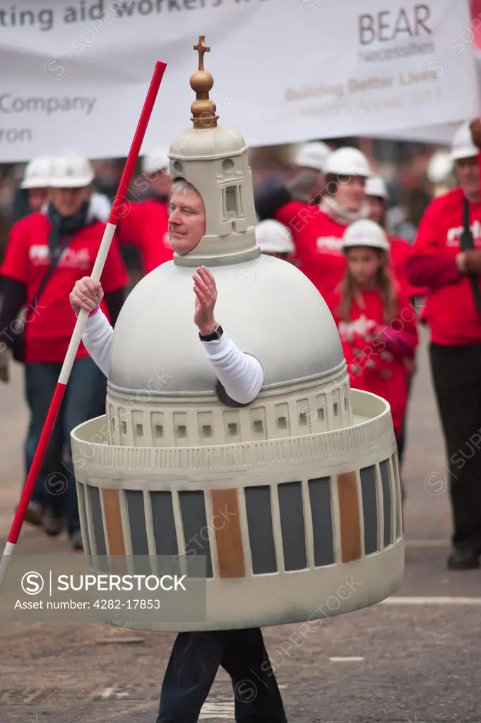 England, London, City of London. A man from the The Worshipful Company of Chartered Surveyors float dressed as the dome of St Paul's Cathedral in the procession at the Lord Mayor's Show in the City of London.