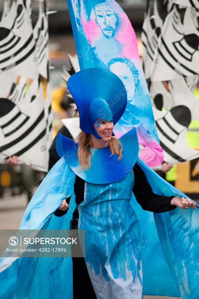 England, London, City of London. A woman wearing a costumed based on the theme 'the Necessities of Life' from the City of London Solicitors Company float in the procession at the annual Lord Mayor's Show in the City of London.