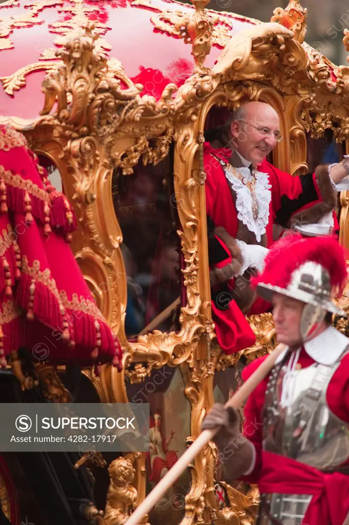 England, London, City of London. The ornate 18th century state coach carrying The Lord Mayor of the City of London, Alderman Michael Bear, in the procession at the Lord Mayor's Show in the City of London. The Lord Mayor is accompanied by members of the Company of Pikemen and Musketeers of the Honourable Artillery Company.