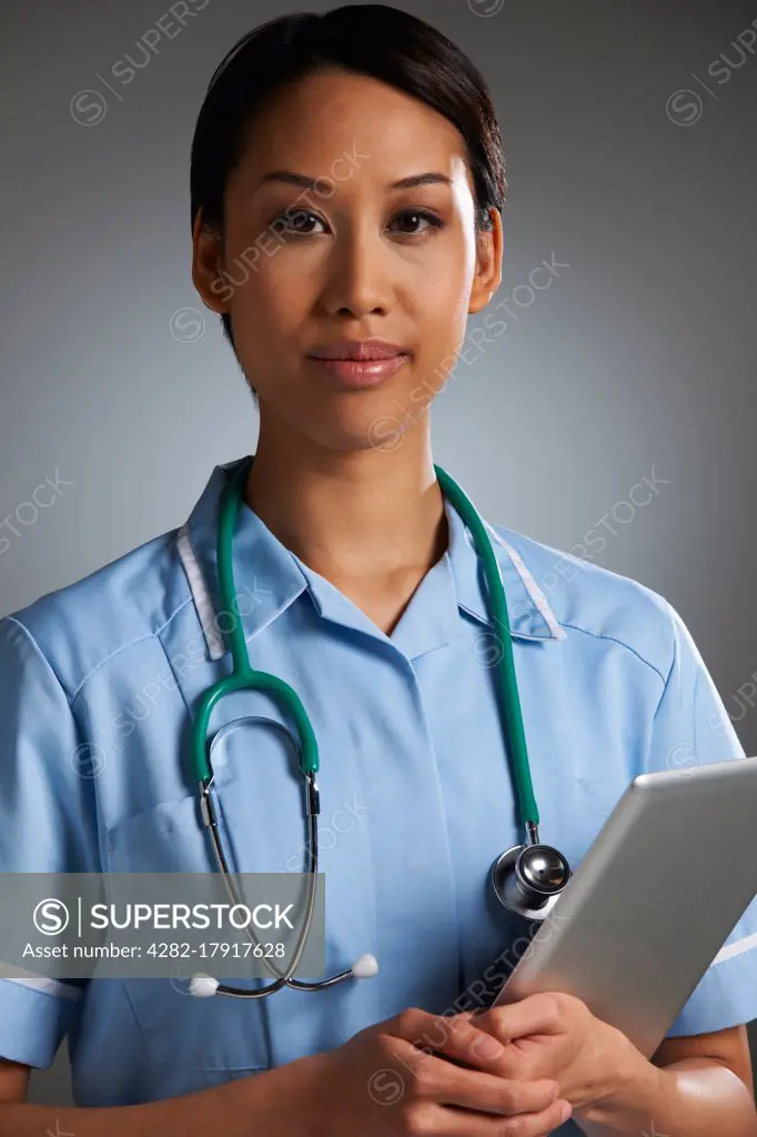 Studio Portrait Of Nurse With Digital Tablet