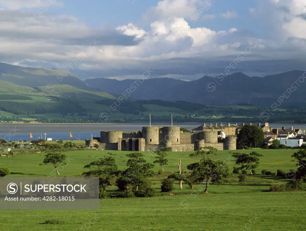 Wales, Anglesey, Beaumaris. A general view of Edward I's Beaumaris Castle looking south to the Menai Strait and the mountains of Snowdonia.