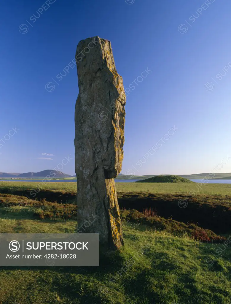 Scotland, Orkney, Ring of Brodgar. Looking from the tall western slab of the Ring of Brodgar stone circle, across the Loch of Stenness to Ward Hill on the island of Hoy.